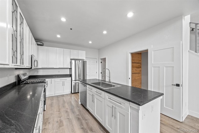 7700 E 29th Ave Unit 102, Denver, CO 80238 - kitchen with appliances with stainless steel finishes, a sink, recessed lighting, white cabinets, and light wood finished floors