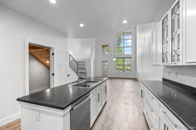 7700 E 29th Ave Unit 102, Denver, CO 80238 - kitchen with a sink, stainless steel dishwasher, light wood-style floors, white cabinets, and recessed lighting