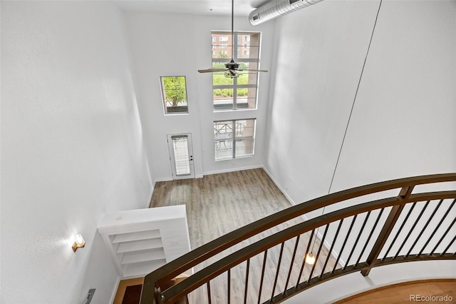 7700 E 29th Ave Unit 102, Denver, CO 80238 - stairway with ceiling fan, wood finished floors, baseboards, and a high ceiling