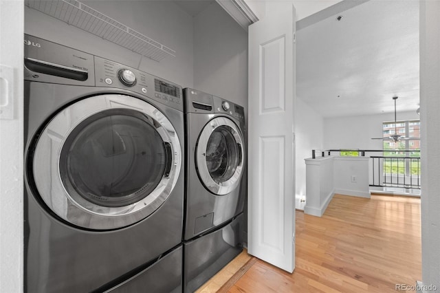 7700 E 29th Ave Unit 102, Denver, CO 80238 - washroom featuring light wood finished floors, a ceiling fan, washer and clothes dryer, and baseboards
