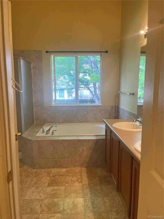 213 Mesa St, Brighton, CO 80601 - bathroom with a garden tub, double vanity, and stone finish floors