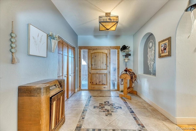 entrance foyer with baseboards and arched walkways