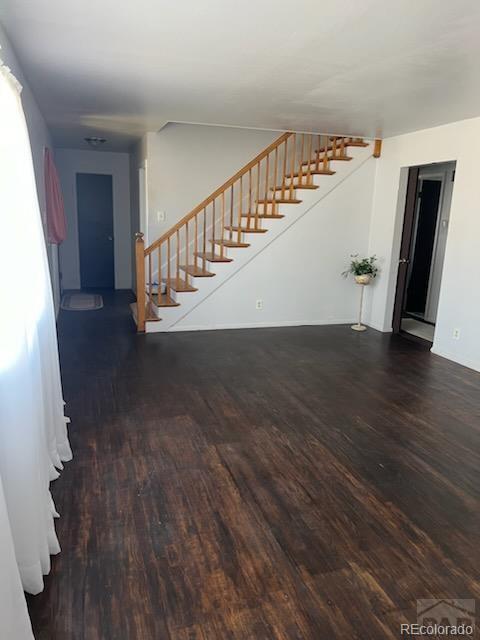 unfurnished living room with dark hardwood / wood-style flooring