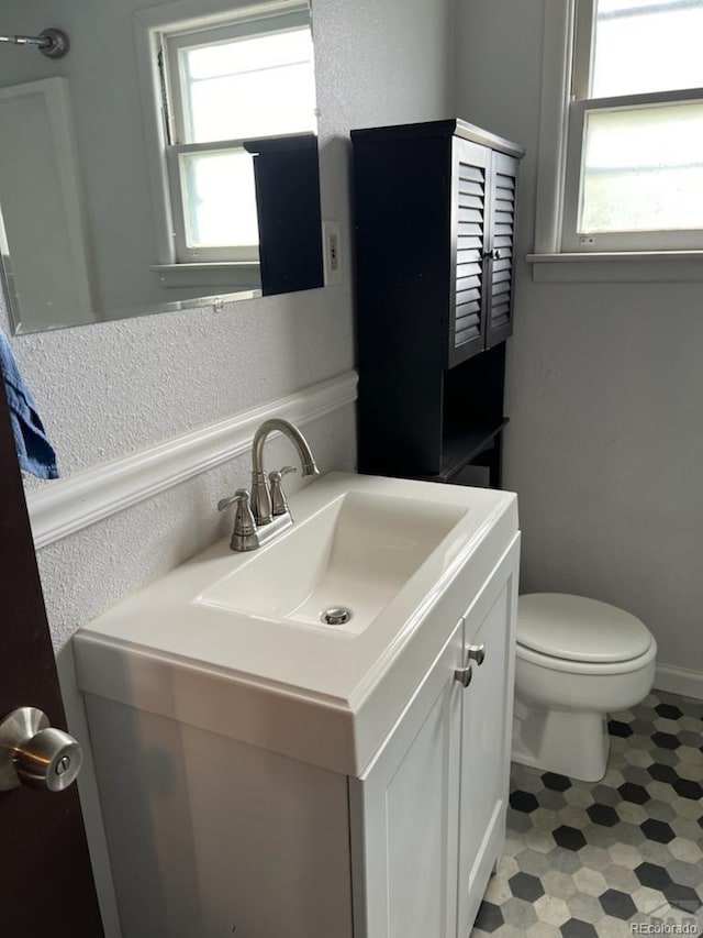 bathroom featuring plenty of natural light, vanity, and toilet