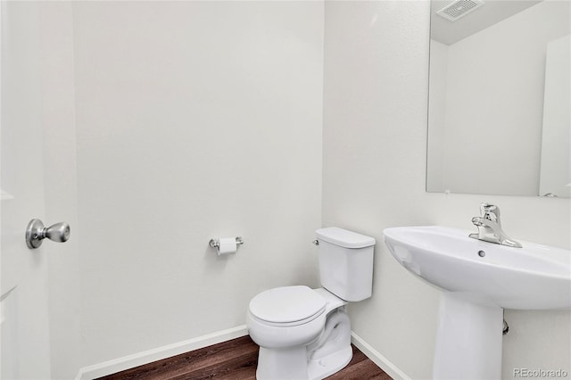 bathroom featuring wood-type flooring and toilet