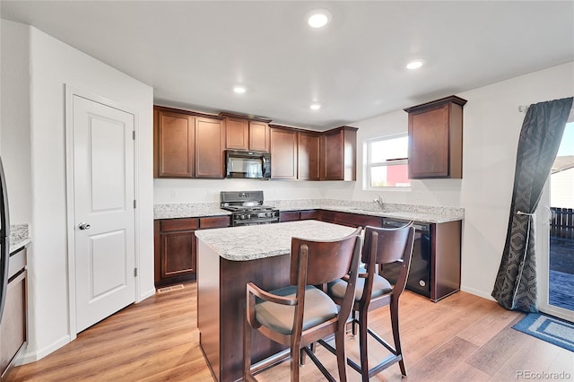 kitchen with sink, a center island, light hardwood / wood-style flooring, and black appliances