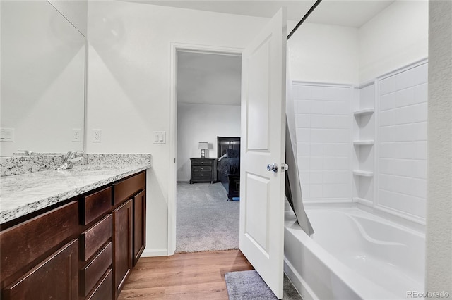 bathroom featuring shower / washtub combination, hardwood / wood-style floors, and vanity