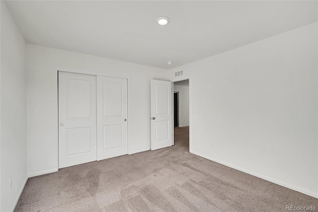 unfurnished bedroom featuring carpet and a closet