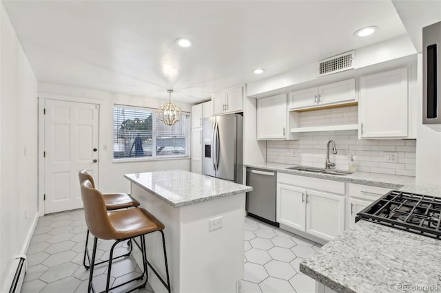 kitchen with sink, white cabinetry, a center island, a baseboard radiator, and appliances with stainless steel finishes