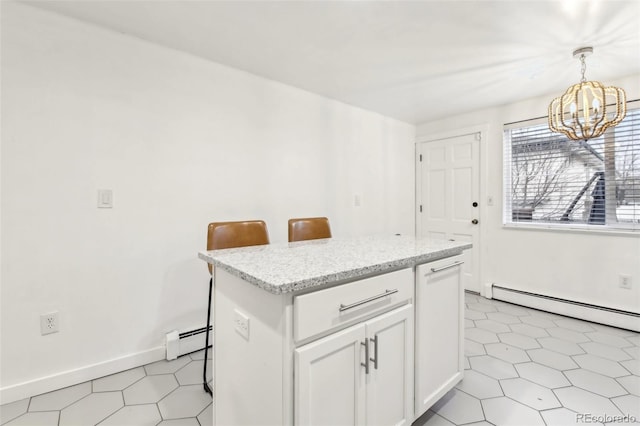 kitchen with a breakfast bar, a baseboard heating unit, white cabinets, a kitchen island, and decorative light fixtures