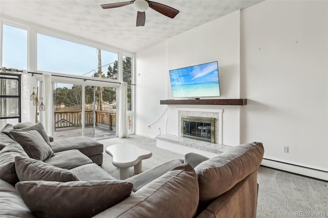 carpeted living room with ceiling fan, floor to ceiling windows, and a premium fireplace