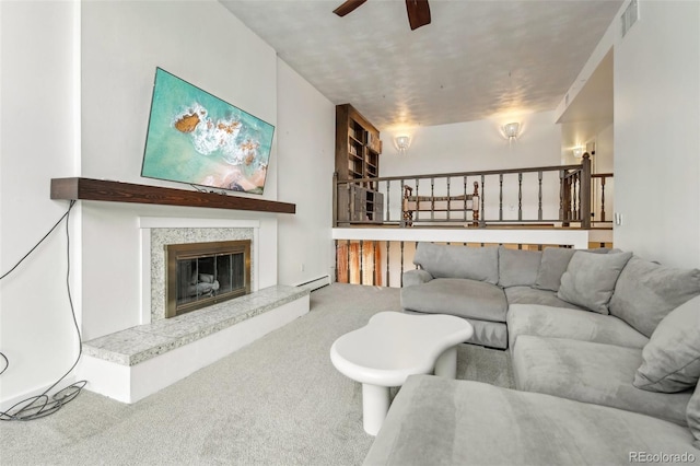 carpeted living room featuring a high end fireplace and ceiling fan