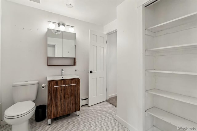 bathroom featuring a baseboard radiator, vanity, and toilet