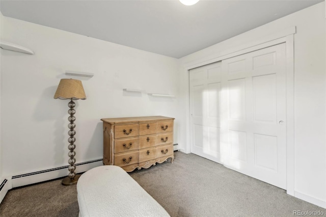 carpeted bedroom featuring a baseboard radiator and a closet