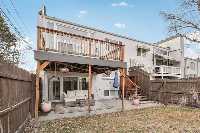 back of house featuring a wooden deck, an outdoor living space, and a patio