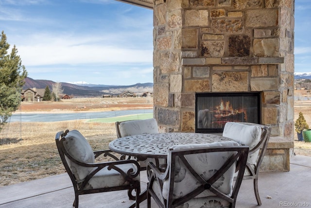 view of patio with an outdoor stone fireplace and a mountain view