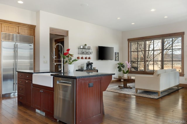 kitchen with a sink, stainless steel appliances, dark wood-type flooring, and recessed lighting