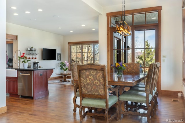dining room featuring dark wood-style flooring, baseboards, and a wealth of natural light
