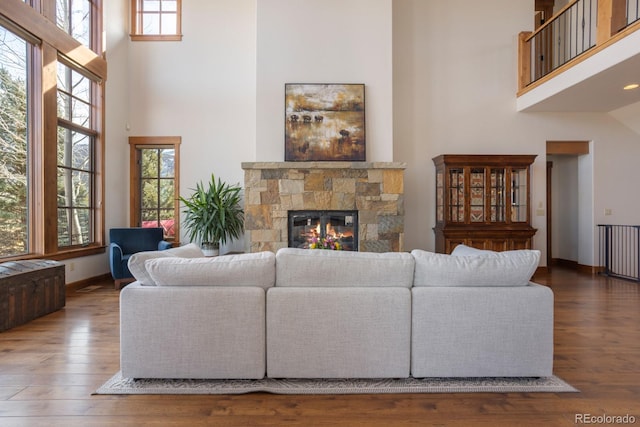 living area featuring a healthy amount of sunlight, a high ceiling, and hardwood / wood-style floors
