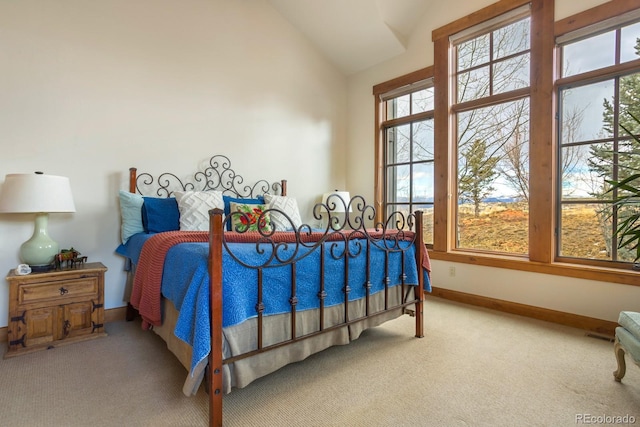 carpeted bedroom featuring baseboards and lofted ceiling