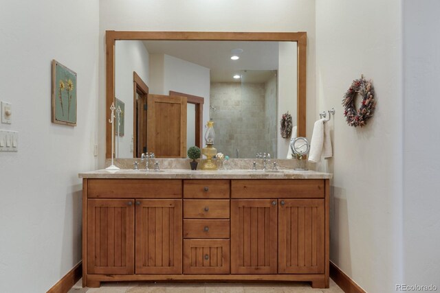 bathroom featuring baseboards, tiled shower, and a sink