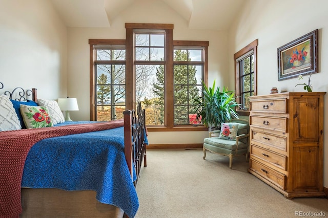 bedroom featuring baseboards, vaulted ceiling, and light carpet