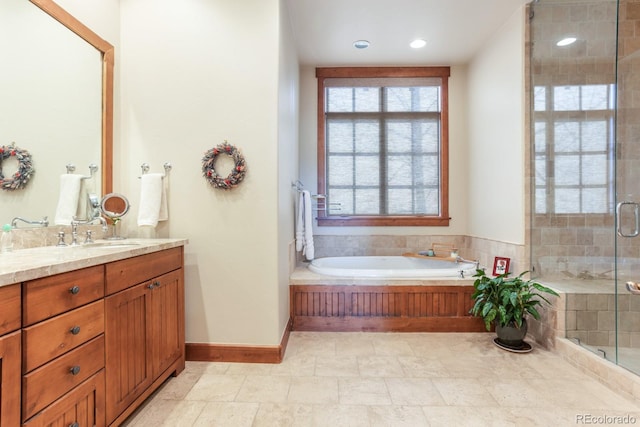 full bath with vanity, baseboards, a shower stall, and a bath