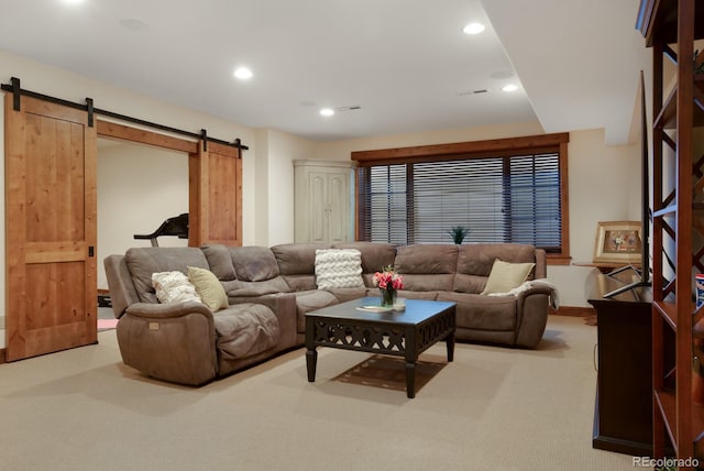 carpeted living room with a barn door, visible vents, and recessed lighting