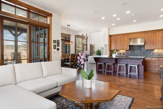 living area with plenty of natural light, recessed lighting, and wood finished floors