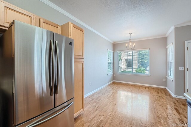 kitchen with stainless steel fridge, light brown cabinetry, light wood-type flooring, and an inviting chandelier