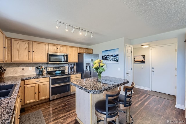 kitchen featuring stainless steel appliances, dark wood-style flooring, backsplash, and a kitchen breakfast bar