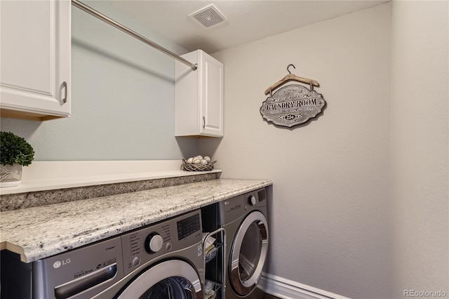 laundry area with cabinet space, visible vents, and washer and dryer