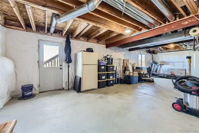 below grade area featuring freestanding refrigerator and a healthy amount of sunlight