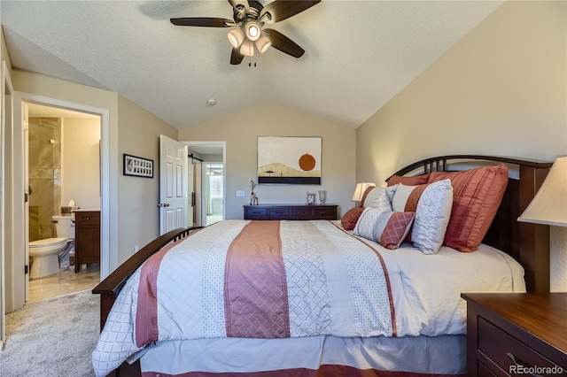 bedroom with connected bathroom, a ceiling fan, vaulted ceiling, and a textured ceiling