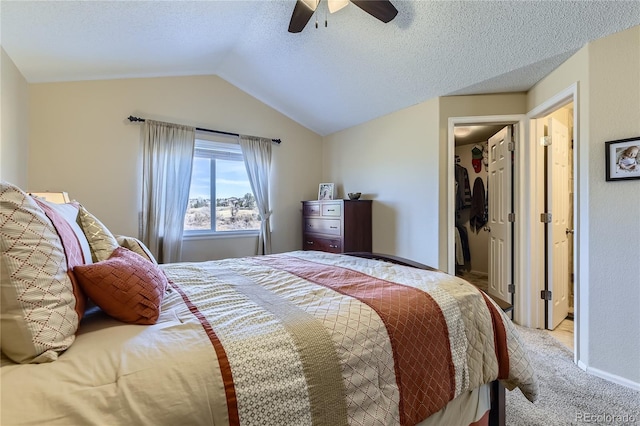 carpeted bedroom with a ceiling fan, vaulted ceiling, and a textured ceiling