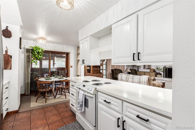 9861 Pecos St, Thornton, CO 80260 - kitchen featuring white electric range oven, white cabinetry, light countertops, and dark tile patterned floors