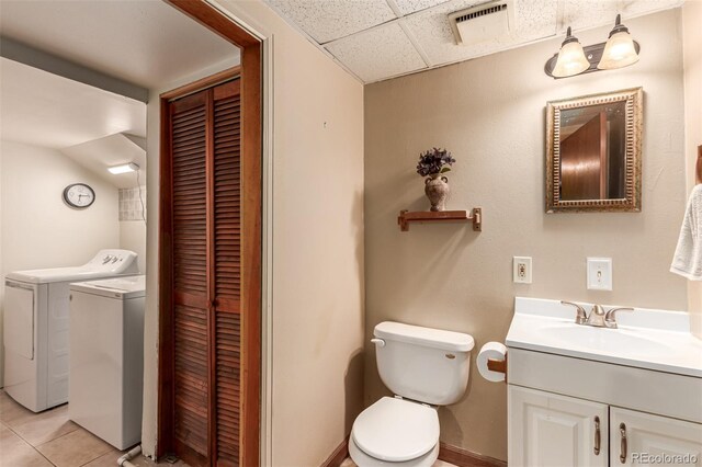 9861 Pecos St, Thornton, CO 80260 - bathroom featuring a closet, washing machine and dryer, vanity, a paneled ceiling, and tile patterned flooring