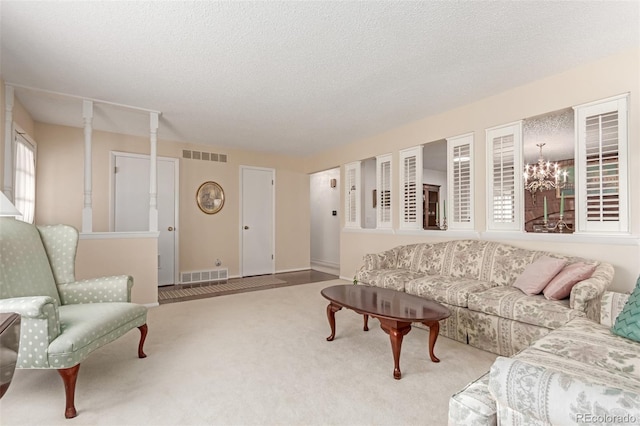 living room with carpet floors, a chandelier, and a textured ceiling