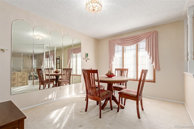 dining space with a textured ceiling and carpet flooring