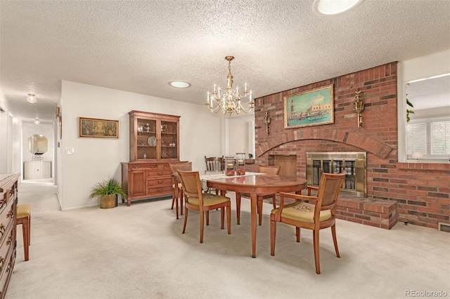 dining space with a brick fireplace, an inviting chandelier, a textured ceiling, and light colored carpet