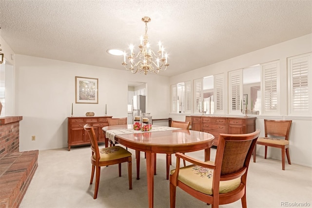 carpeted dining area with a notable chandelier and a textured ceiling