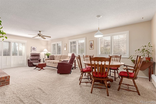 dining space featuring ceiling fan, carpet, and a textured ceiling