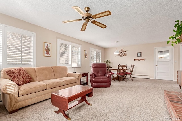 carpeted living room with a textured ceiling, ceiling fan, and a wealth of natural light