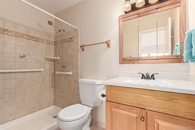 bathroom with toilet, vanity, and tiled shower