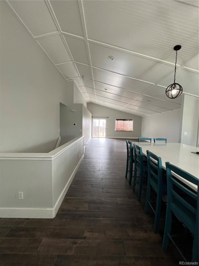hall featuring baseboards, dark wood-style floors, and vaulted ceiling