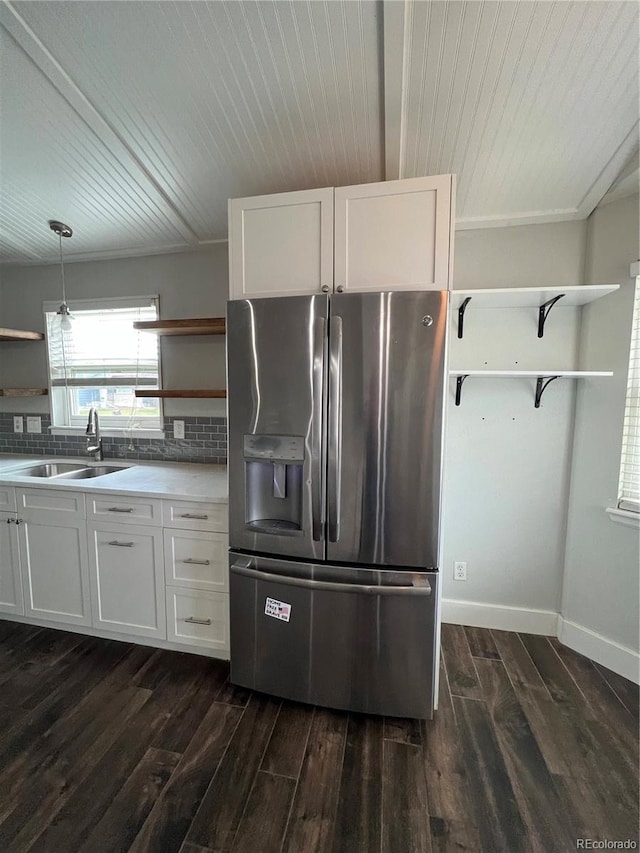 kitchen with stainless steel fridge, open shelves, a sink, and wooden ceiling