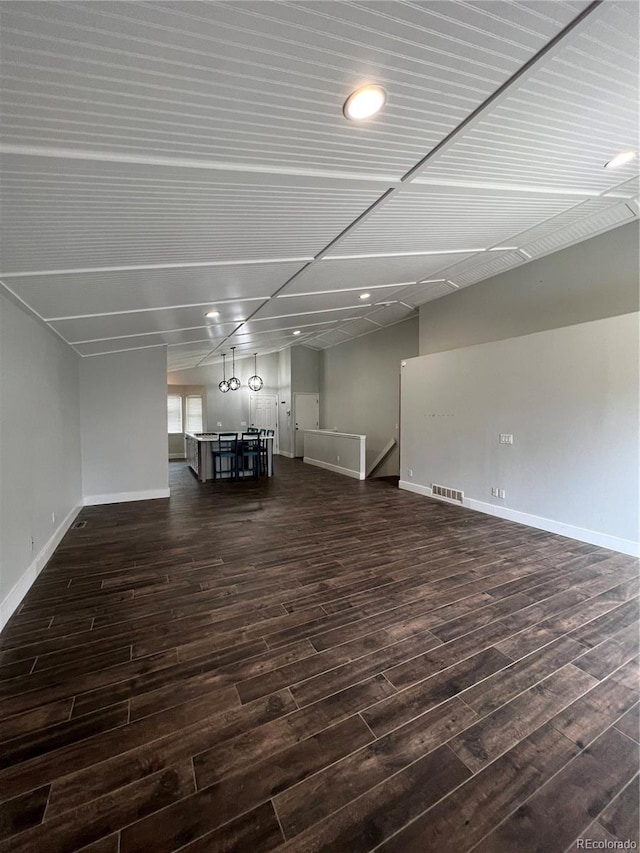 below grade area with baseboards, visible vents, recessed lighting, and dark wood-type flooring