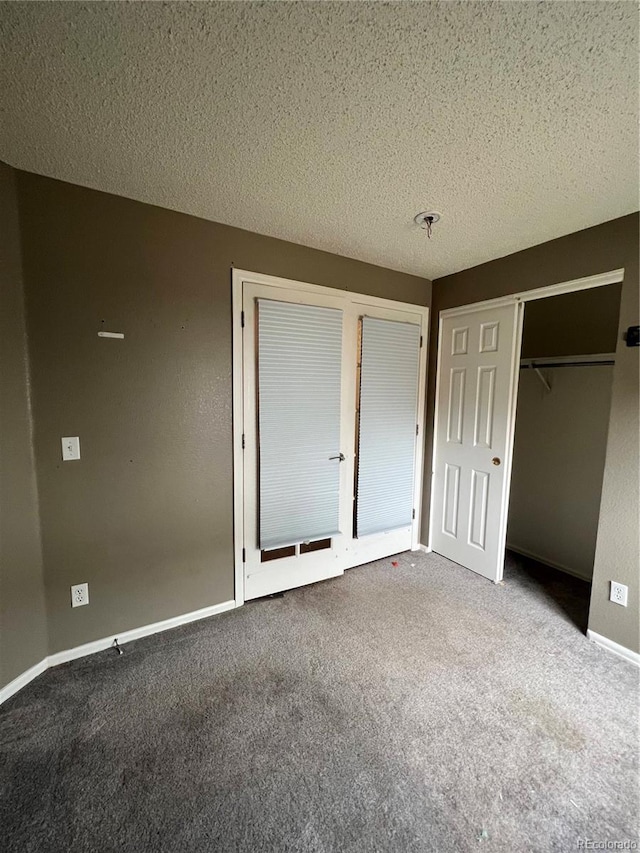 unfurnished bedroom with baseboards, carpet flooring, and a textured ceiling