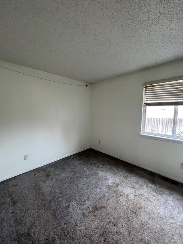 carpeted empty room with a textured ceiling