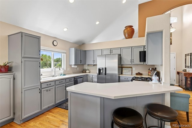 4737 E 127th Ave, Thornton, CO 80241 - kitchen with stainless steel fridge with ice dispenser, gray cabinets, a peninsula, a kitchen breakfast bar, and light wood-style floors